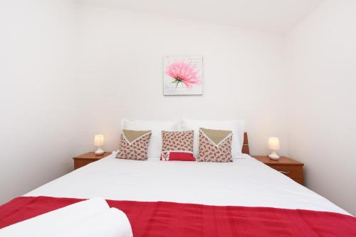 a bedroom with a large white bed with pillows at Apartment Lola Maria in Zadar