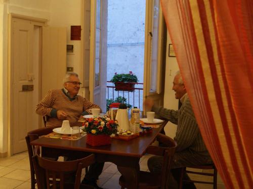 two men sitting at a table in a restaurant at B&B Borgo San Martino in Monopoli