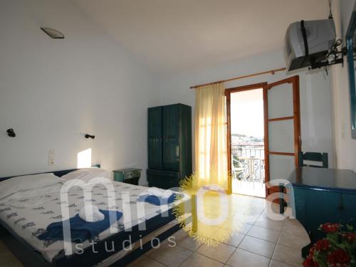 a bedroom with a bed and a sliding glass door at Mimoza Studios in Skiathos Town