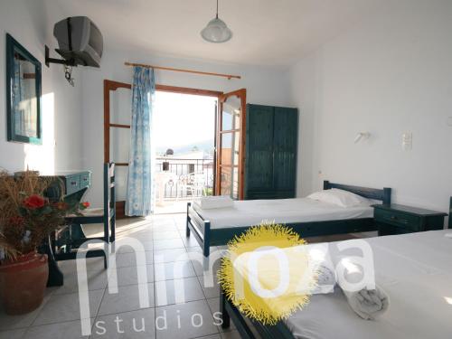 a bedroom with two beds and a balcony at Mimoza Studios in Skiathos Town