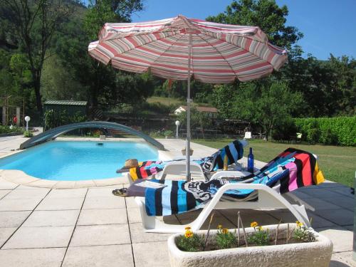 2 tumbonas y una sombrilla junto a la piscina en Au Verger B&B, en Sospel