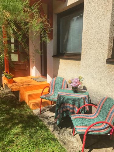 two chairs and a table in front of a house at Guest House Isidora in Arilje