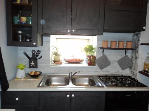 cocina con fregadero y ventana en B&B Maria Rosaria Home, en San Marzano sul Sarno