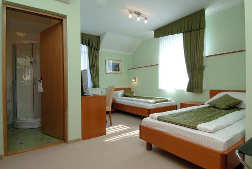a hotel room with two beds and a bathroom at Hotel Varazdin in Varaždin