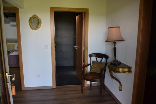 a hallway with a chair and a lamp and a door at Quinta da Boa Ventura in Bragança