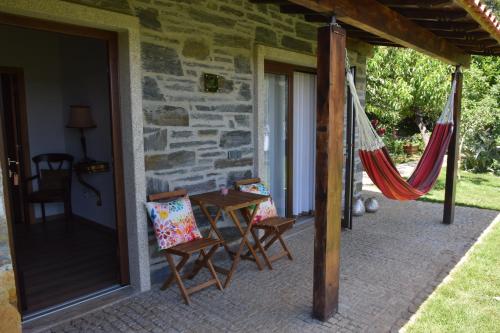 a porch with chairs and a hammock on it at Quinta da Boa Ventura in Bragança