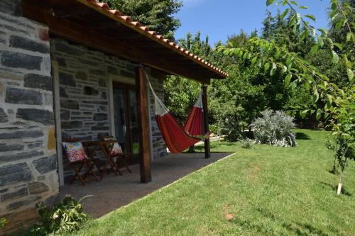 a patio with a hammock outside of a house at Quinta da Boa Ventura in Bragança