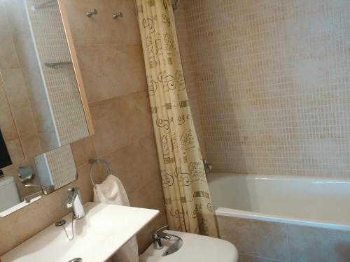 a bathroom with a tub and a toilet and a sink at Lydia´s House in Comarruga