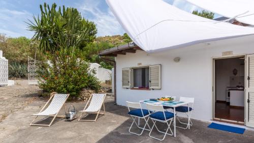 a patio with a table and chairs in front of a house at Vulcano Dimore in Vulcano