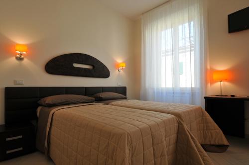 a bedroom with a bed and a large window at B&B Il Grifone in Pistoia