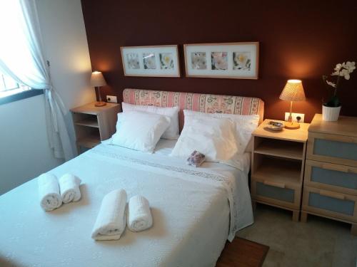 a bedroom with a bed with towels on it at Lydia´s House in Comarruga