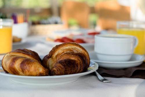 zwei Croissants auf einem Teller auf dem Tisch in der Unterkunft Hotel Mon Repos in Sirmione