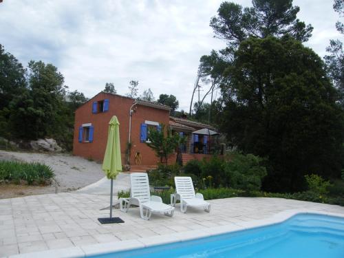 une terrasse avec un parasol, deux chaises et une piscine dans l'établissement Villa Margaux, à Sillans-la-Cascade