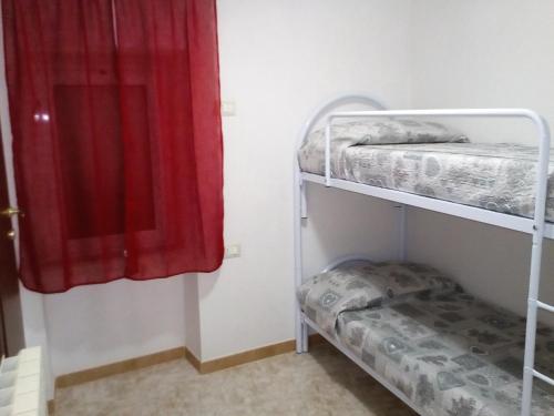 a room with two bunk beds and a red curtain at Casa Elsa in Biassa