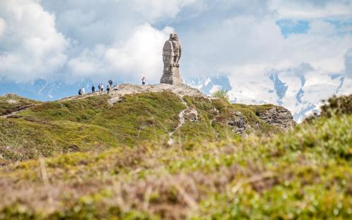 a group of people standing on a hill with a monument at Chalet Seviann in Rosswald