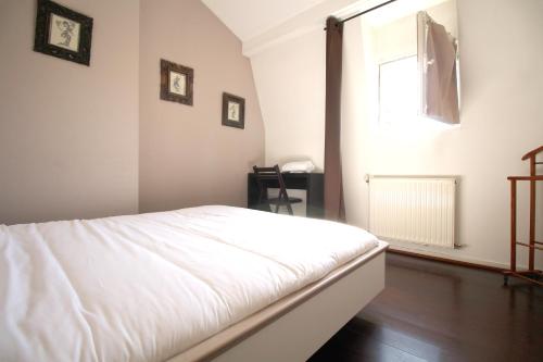 une chambre avec un lit blanc et une fenêtre dans l'établissement Appart Hypercentre - Le Saint Projet, à Bordeaux