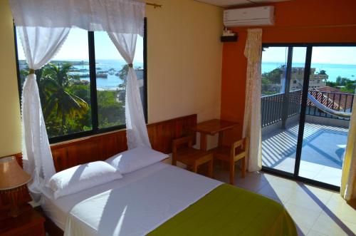 1 dormitorio con 1 cama y balcón con vistas. en Dolphin House, en Puerto Baquerizo Moreno