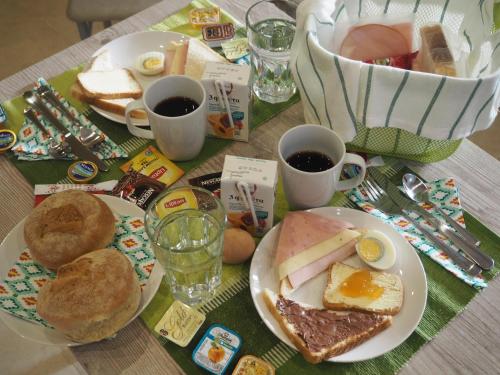 una mesa con platos de desayuno y tazas de café en Zonita Guest House, en Nea Plagia