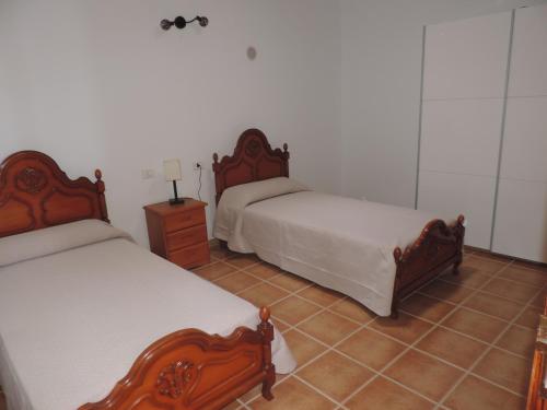 sypialnia z 2 łóżkami i podłogą wyłożoną kafelkami w obiekcie Casa Pedro w Costa Teguise