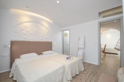 a white bedroom with a large bed in a room at Villa Adriana Hotel in Agios Prokopios