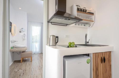 a small kitchen with a sink and a counter top at Villa Adriana Hotel in Agios Prokopios