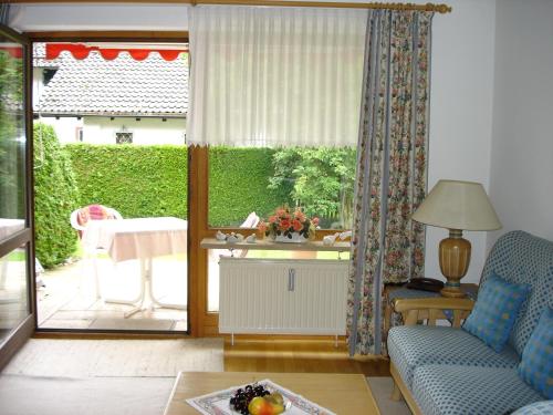 ein Wohnzimmer mit einem Sofa und einer Glasschiebetür in der Unterkunft Ferienwohnanlage Partnach in Garmisch-Partenkirchen