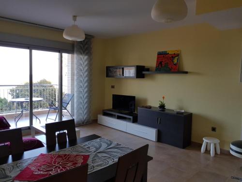 a living room with a dining table and a television at Salomé Beach Apartments in Los Alcázares