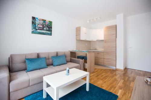ein Wohnzimmer mit einem Sofa und einem Tisch in der Unterkunft Jelena Apartment in Doboj