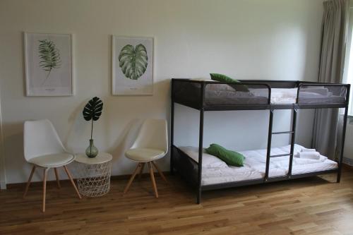 a black bunk bed in a room with two chairs at Hensbacka Hotell in Munkedal