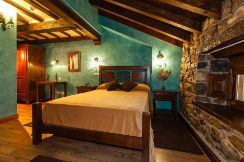 a bedroom with a bed and a stone wall at Hotel Spa Casona La Hondonada in Terán