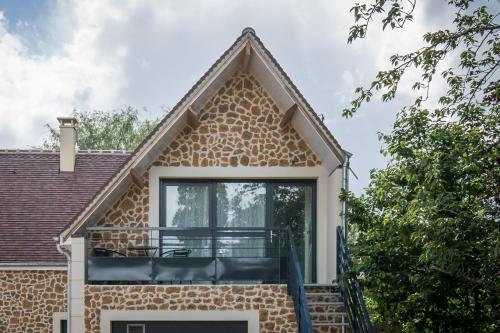 a house with a window and a balcony at Chambre d'hôtes La Bourdonnaise in Bourdonné