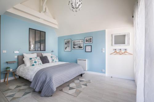 a bedroom with blue walls and a large bed at Chambre d'hôtes La Bourdonnaise in Bourdonné