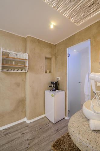 a room with a small refrigerator and a small table at Villa Adriana Hotel in Agios Prokopios