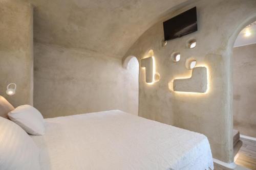 a bedroom with a bed and a tv on the wall at Villa Adriana Hotel in Agios Prokopios
