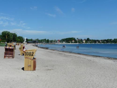 a beach with chairs and people in the water at Apartment Lütte Bris in Eckernförde