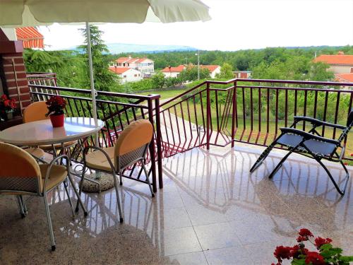 a balcony with a table and chairs and an umbrella at Apartment Eda in Labin