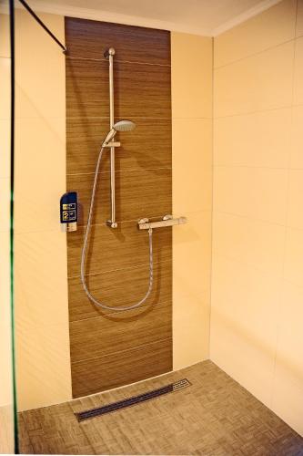 a shower with a hose on a wall at Hotel Restaurant Doppeladler in Rees