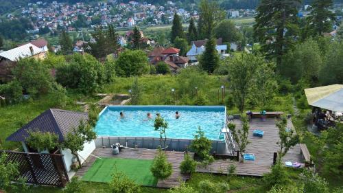een uitzicht over een zwembad met mensen erin bij Vila Alunis in Buşteni