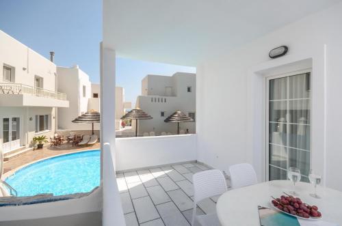 a balcony with a pool and a table and chairs at Villa Adriana Hotel in Agios Prokopios