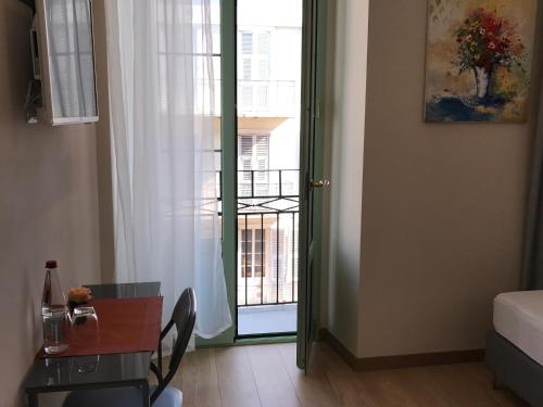 Cette chambre dispose d'une porte s'ouvrant sur un balcon. dans l'établissement Boutique Hôtel Neptune Nice, à Nice