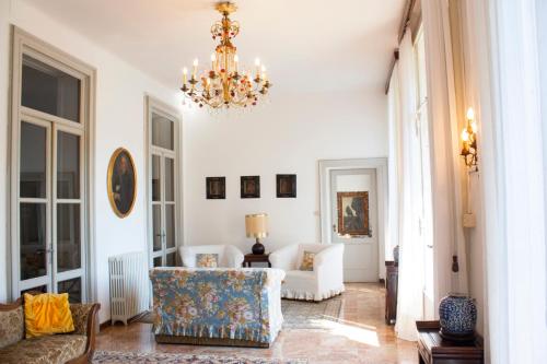 sala de estar con lámpara de araña y sofá en Villa Ruscone, en Lasnigo