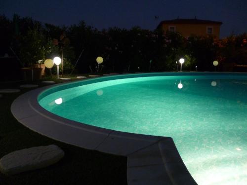 a large swimming pool at night with lights at Chez Patrick Roujan in Roujan