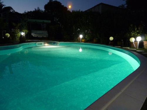 a large swimming pool at night at Chez Patrick Roujan in Roujan