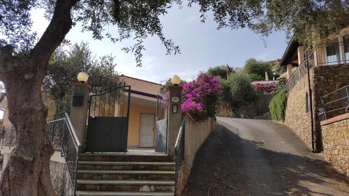 a house with stairs and a tree on a street at Villa Jone in Diano Marina