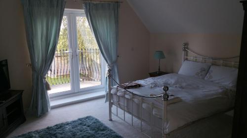 グラストンベリーにあるMillbatch Farmのベッドルーム1室(ベッド1台、大きな窓付)