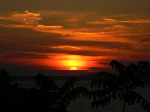a sunset with the sun in the sky at Hodak Apartment in Nerezine