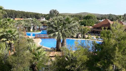 una vista aérea de una piscina del complejo con palmeras en Apartament la Punta de la Móra, en La Mora