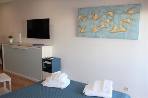 a room with a bed with a tv and towels at Vilamoura Dolphin Studio in Vilamoura