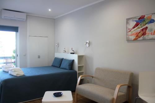 a bedroom with a bed and a chair at Vilamoura Dolphin Studio in Vilamoura