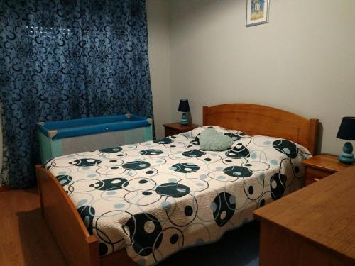 1 dormitorio con 1 cama con edredón blanco y negro en Herois Apartment, en Damaia